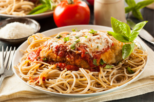 Chicken Parmesan on a bed of spaghetti topped with melted mozzarella chess and parsley