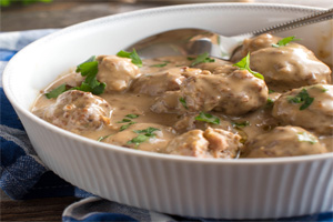 Homemade meatballs served in a deep cream sauce topped with parsley