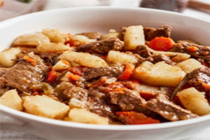 Bowl of stew with meat, potatoes, and vegetables